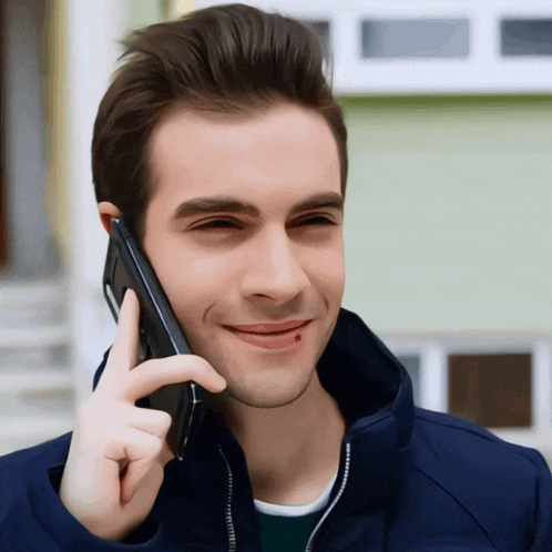 a man with a red spot on his cheek is smiling while talking on a cell phone
