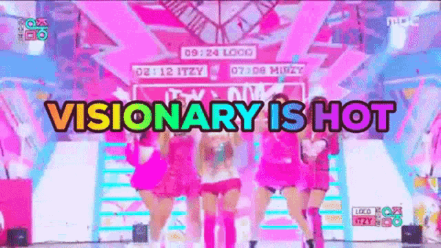 a group of women are dancing on a stage and the words visionary is hot are written above them .