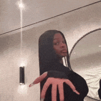 a woman is taking a selfie in front of a mirror while holding her hand up