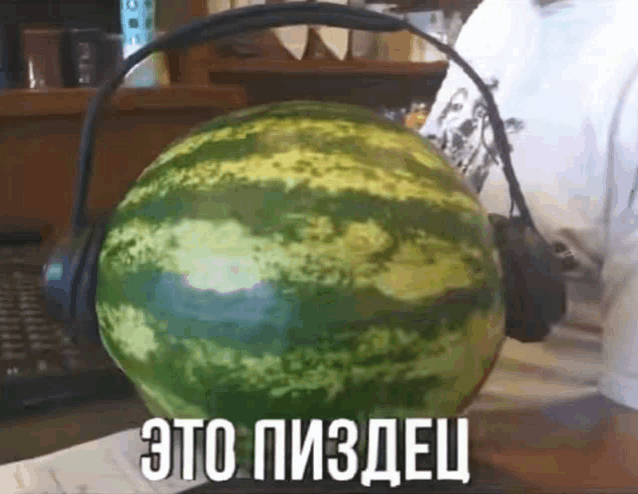 a person wearing headphones is holding a watermelon that says это пиздац
