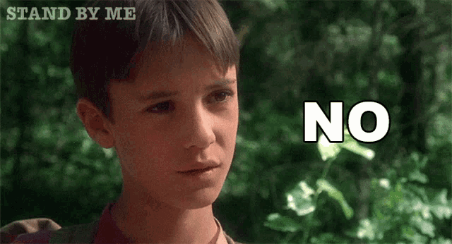 a young boy says no in front of a sign that says " stand by me "