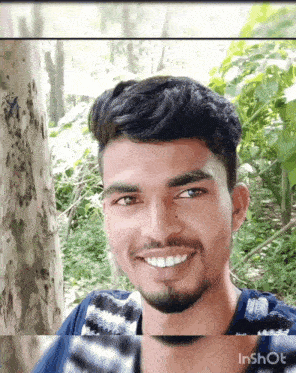 a man with a beard is smiling in front of trees