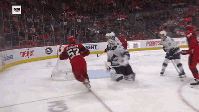 a hockey player with the number 52 on his jersey is skating around the ice