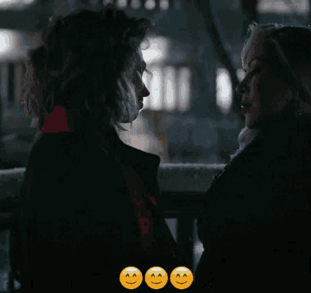 a couple of women looking at each other with smiley faces in the background