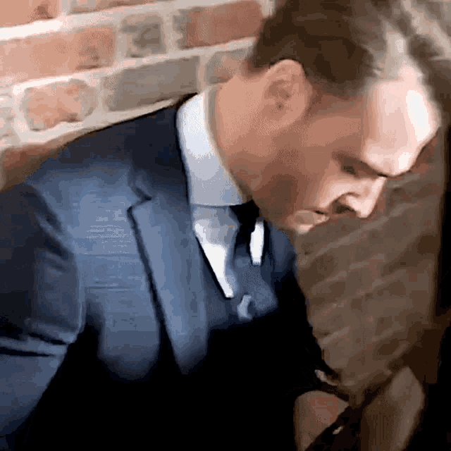 a man in a suit and tie is looking down
