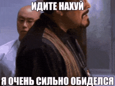 a man with a beard stands in front of another man with a foreign language caption