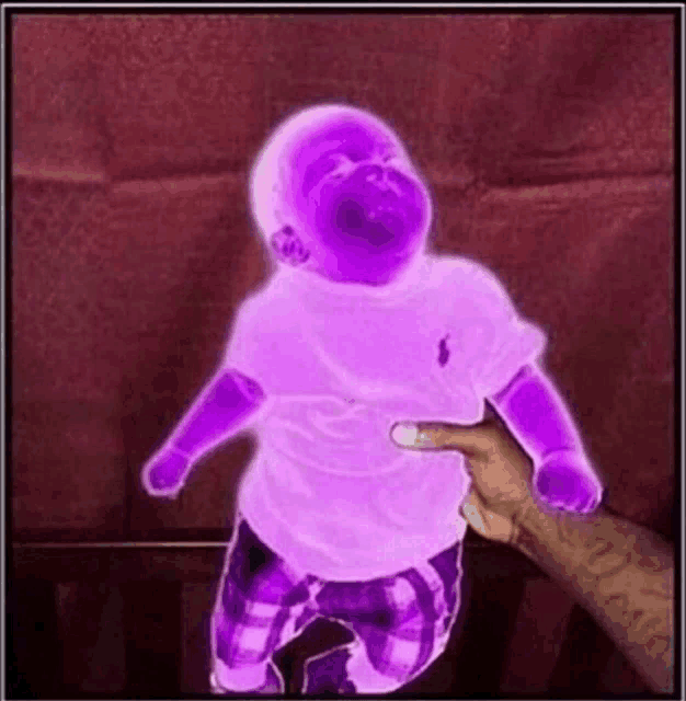 a person is holding a purple baby in their hand