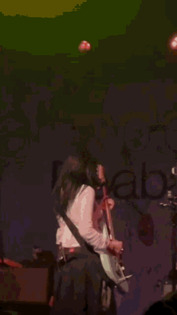 a woman is singing into a microphone while playing a guitar .