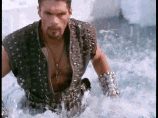 a man is standing in the water with a sword in his hand .