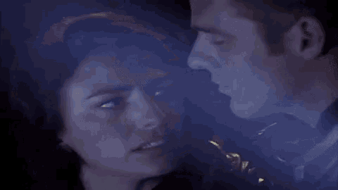 a man and a woman are standing next to each other in the dark