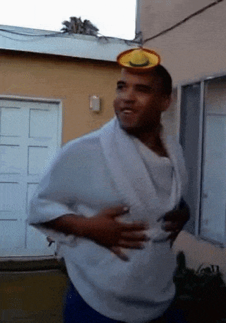a man wearing a white shirt and blue shorts has a yellow hat on his head