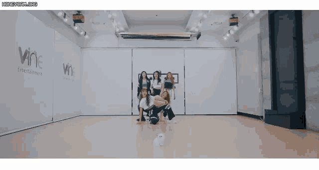 a group of women are posing for a picture in a dance studio with the word wine on the wall