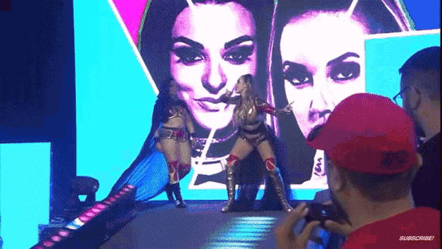 a man in a red hat is taking a picture of a wrestler