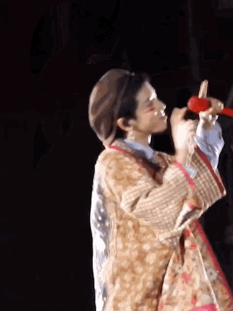 a man in a clown costume is holding a microphone