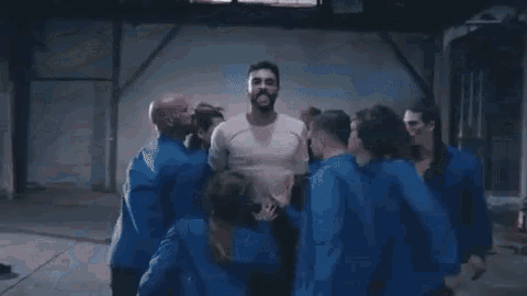 a man is holding a woman in his arms in a gym .