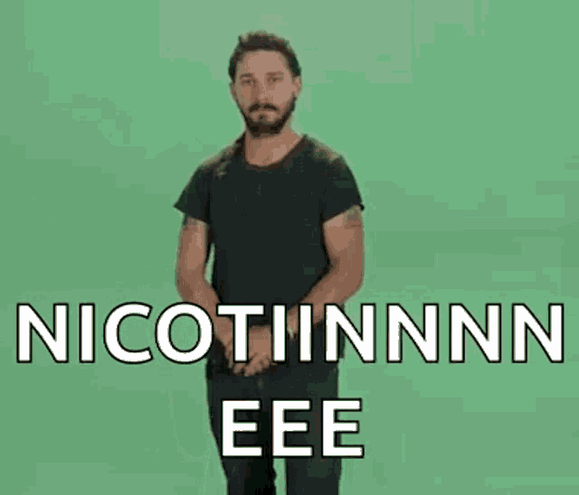 a man in a black shirt is standing in front of a green screen and says nicotinnn eee .