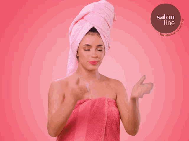 a woman with a towel wrapped around her head is pointing to a salon line logo