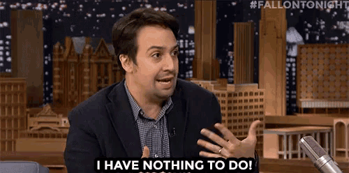 a man in a suit is talking into a microphone and says i have nothing to do .