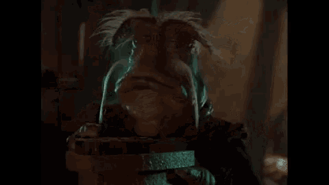 a cartoon character with a beard and mustache is drinking water from a bucket in a dark room .