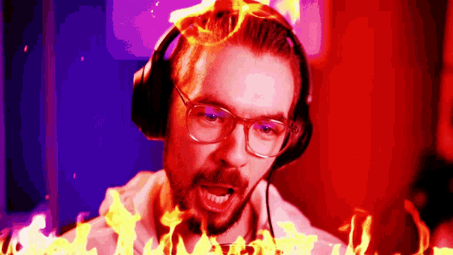 a man wearing glasses and headphones is surrounded by fire