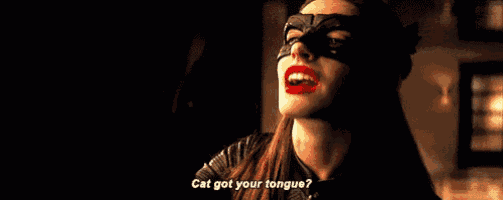 a woman wearing a cat mask and red lipstick is talking to another woman .