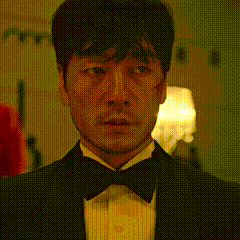 a man in a tuxedo and bow tie is standing in a room .