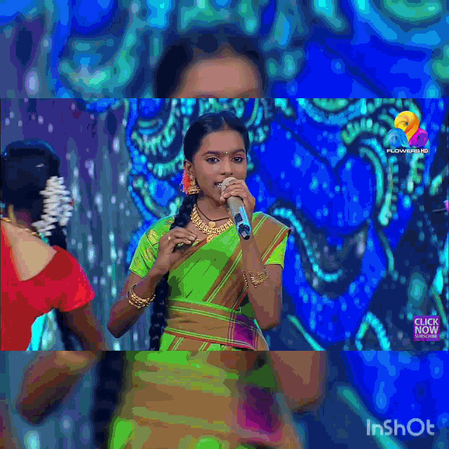 a woman singing into a microphone in front of a blue background that says inshot
