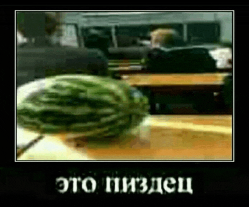 a watermelon is sitting on a table in front of a group of people