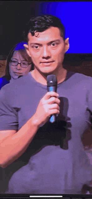 a man is holding a microphone in front of a woman