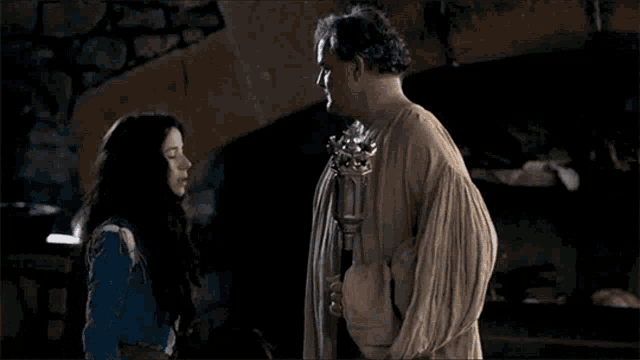 a man and a woman are standing next to each other and talking .