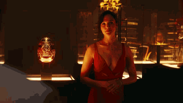 a woman in a red dress is standing in front of a glass display