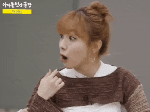 a woman in a brown sweater is pointing at something with the name kepler on the bottom right