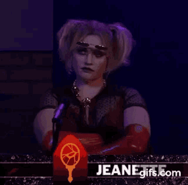 a woman is sitting in front of a microphone in a dark room .