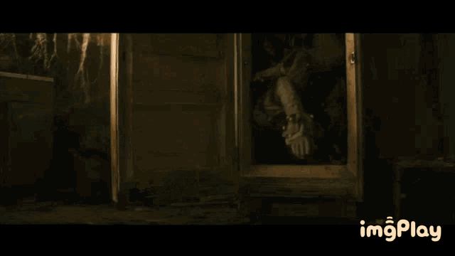 a clown is sitting in a chair in a dark room .