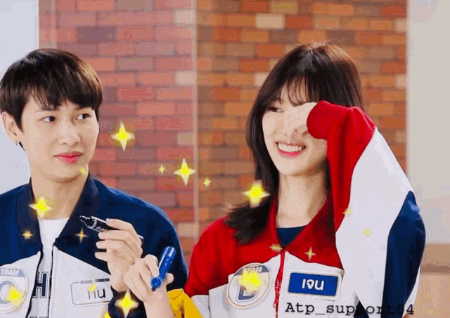a man and a woman are standing next to each other and the woman has the name 19u on her jacket