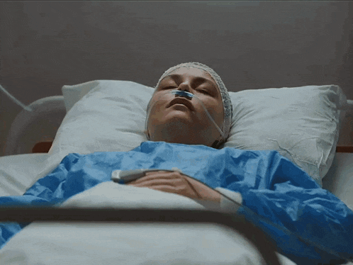 a woman in a hospital bed with an oxygen mask on her face