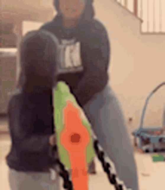 a woman is holding a water gun next to a child .