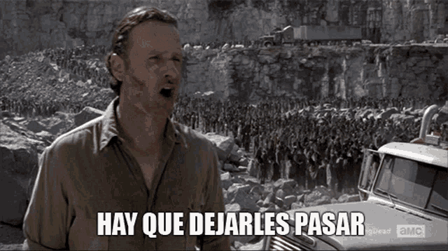 rick grimes from the walking dead says hay que dejarlos pasar in front of a crowd of zombies