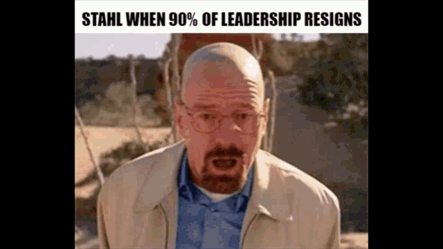 a man with a beard and glasses is standing in the desert .