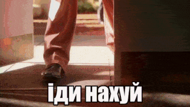 a person is walking in a doorway with the words i di naxyi written on the floor