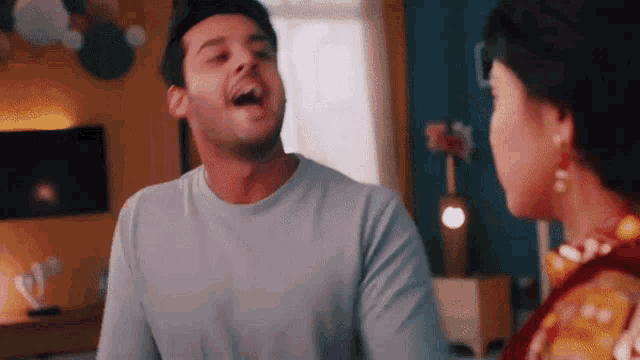 a man and a woman are laughing together in a living room