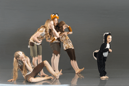a girl in a skunk costume stands in front of a group of girls