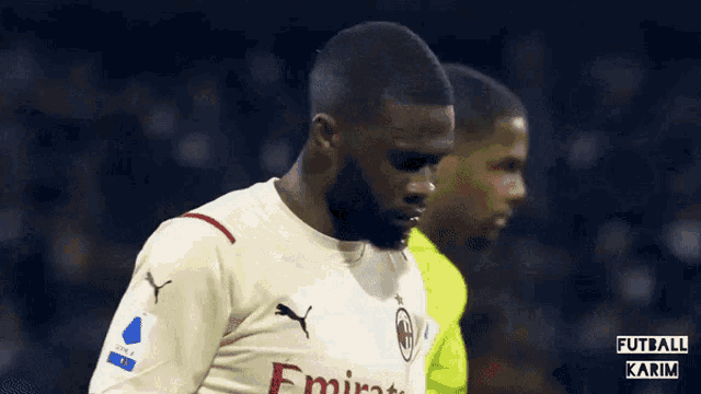 a soccer player wearing a white jersey with the word emirates on it