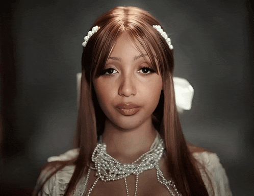 a woman wearing a pearl headband and a pearl necklace