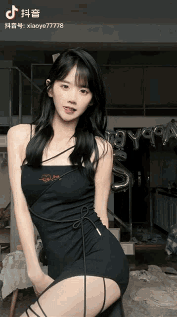 a girl in a black dress is standing in front of balloons and a sign that says xiaoye7778