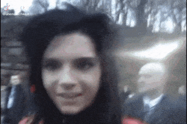a woman with long black hair is smiling and looking at the camera .