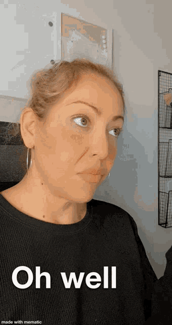 a woman in a black shirt is making a funny face and says oh well