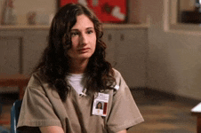 a woman in a prison uniform has a badge on her chest that says " id "