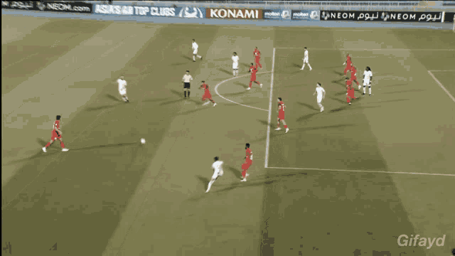 a group of soccer players on a field with a konami banner in the background