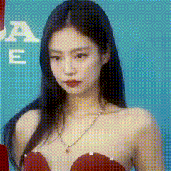 a woman in a red dress is standing in front of a blue background .